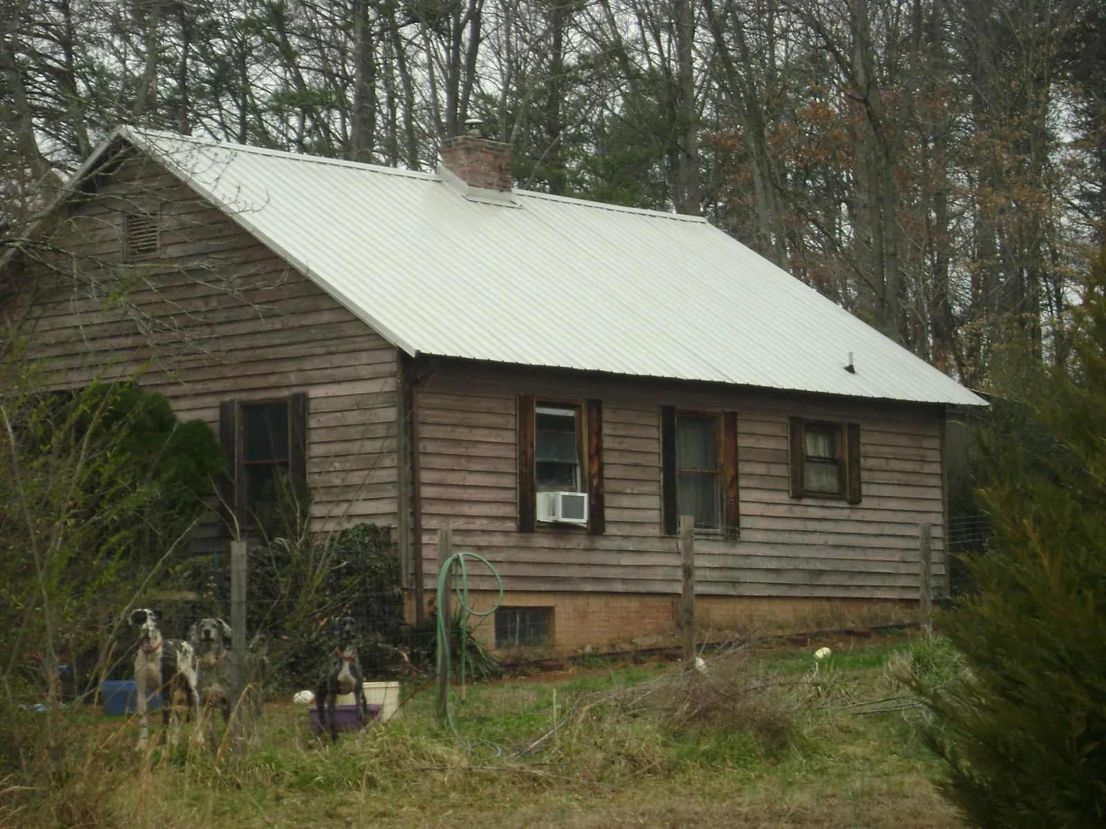 White metal roof on an old wood sided farmhouse, from a Metal Roof Installation job in Alton